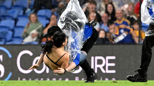 Streaker, Javon Johanson is tacked by a security guard during the Titans clash with Parramatta. Picture: Bradley Kanaris/Getty Images