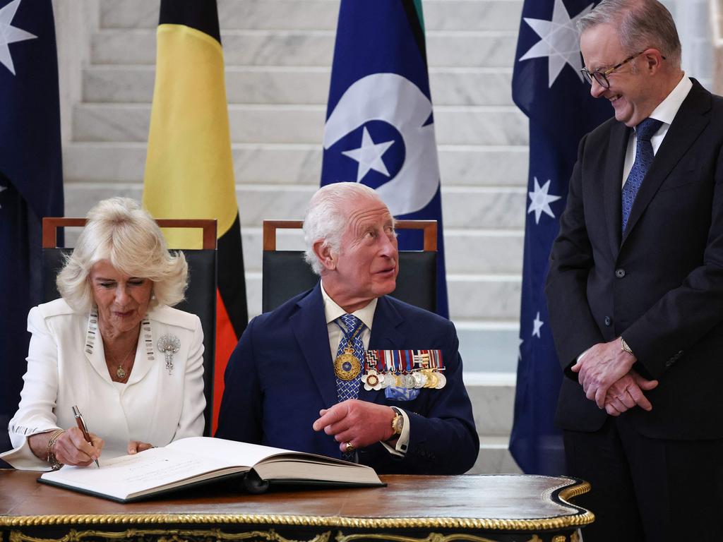 King Charles III talks to Australia's Prime Minister Anthony Albanese as he and Queen Camilla sign a visitors' book in the Marble Foyer of Parliament House in Canberra. Picture: AFP