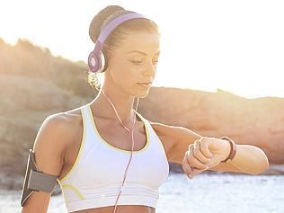 Young woman on the beach using smart watch