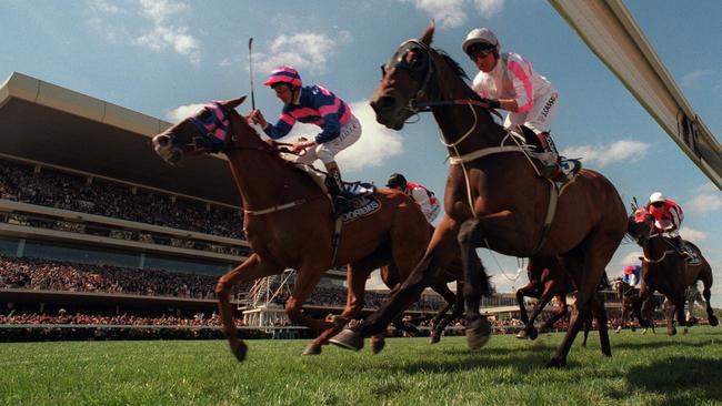 Jim Cassidy rides Might and Power on the inside to their Melbourne Cup victory in 1997, ahead of Greg Hall on Doriemus outside.