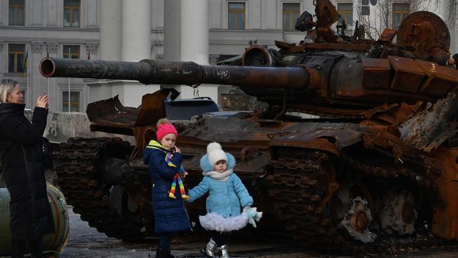 Children walk past a tank at the open air exhibition of destroyed Russian equipment in Kyiv.