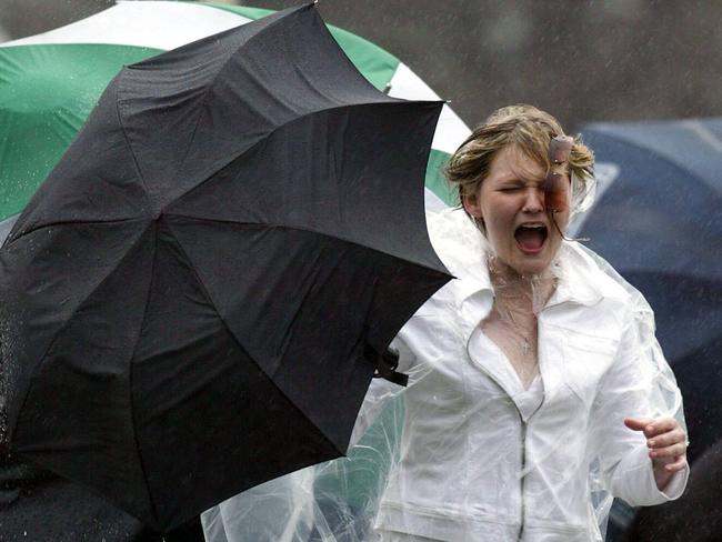 Melbourne’s unreliable weather sparks chaos as racegoers are forced to shelter from the wind and rain. Picture: George Salpigtidis