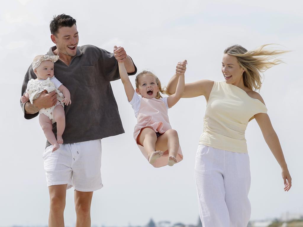 Josh Battle with his partner Casey Ollie and daughters Billie (4) and Bobbi (7 months) and Edithvale beach. Picture: Michael Klein