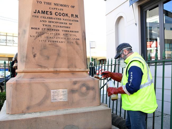 A worker paints over graffiti on a Captain Cook statue at Randwick in Sydney on June 15. Picture: AAP