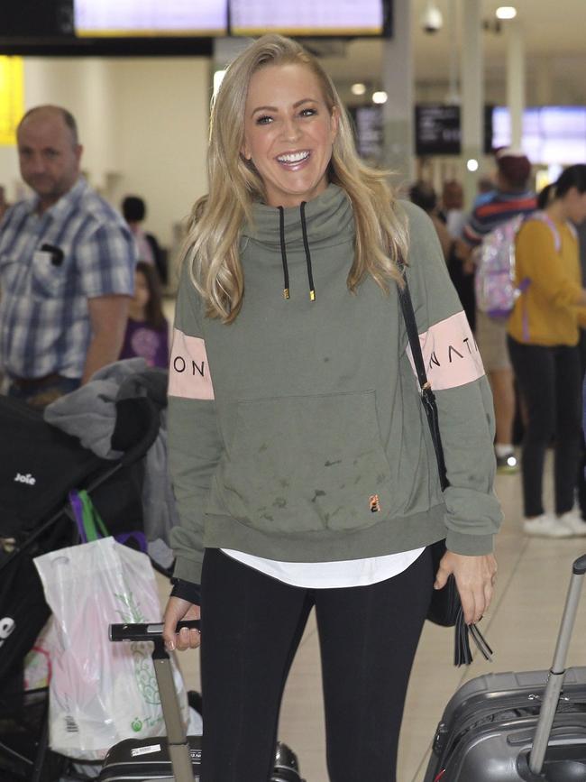 Mum-of-three Carrie Bickmore was casual and all smiles as she left the airport... Picture: Media Mode