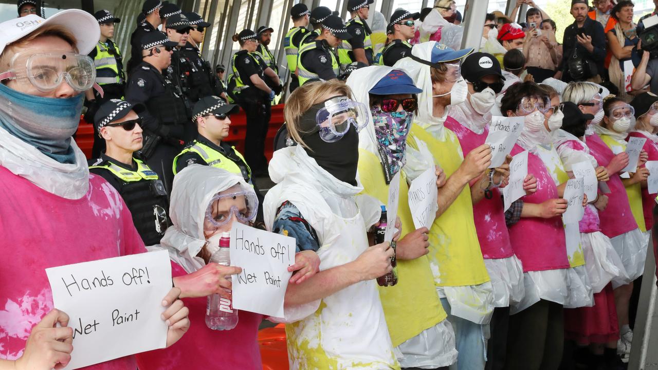 Protesters wearing protective gear and covered in wet paint. Picture: David Crosling/AAP