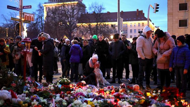 People lay flowers at a makeshift memorial near the shuttered Christmas market. Picture: Getty