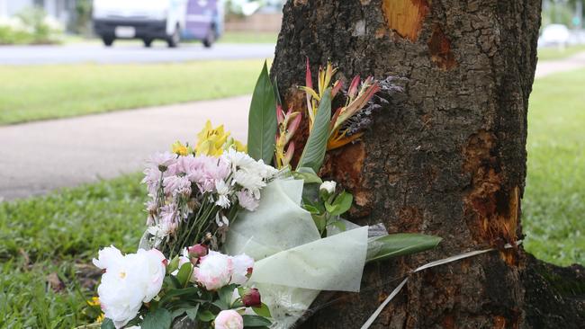 Floral tributes as the scene of a fatal traffic crash at Manoora, where an allegedly stolen Toyota Yaris left Pease St near the Saltwater Creek bridge and hit a tree and Bradley Smith, died. Photo: Brendan Radke