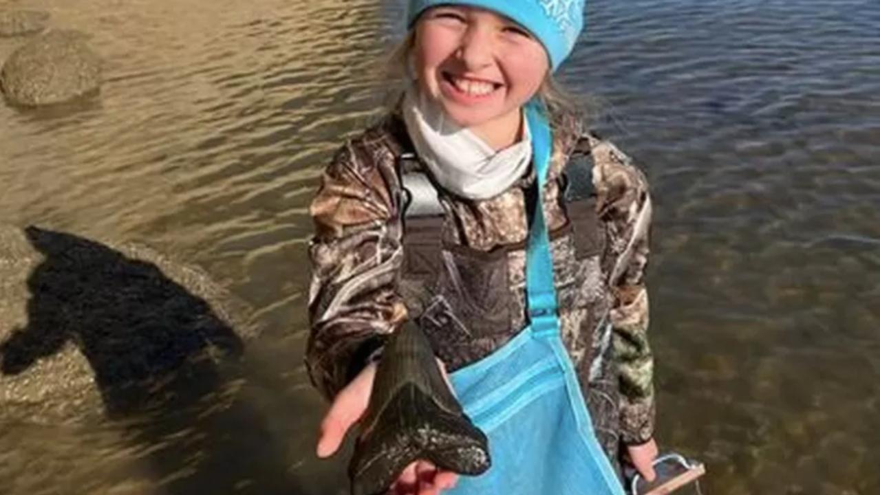 Molly Sampson, 9, holds the megalodon tooth she found at a Maryland beach in the US on Christmas Day. Picture: Facebook