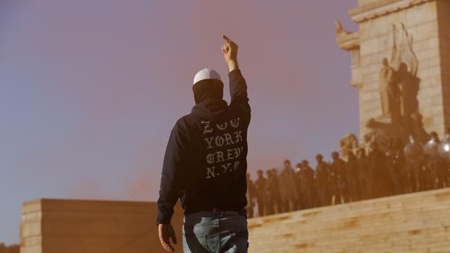 A demonstrator gestures at police around the Shrine of Remembrance during a protest against Covid-19 regulations in Melbourne on September 22.