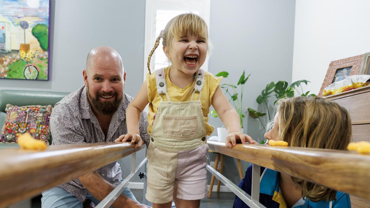 Tallulah doing her walking physio at home with the help of dad Chris and big brother Finn. Picture Lachie Millard