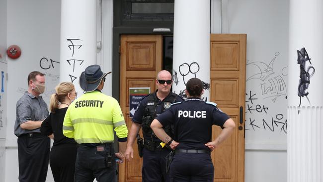 Police officers investigate the crime scene with council officers and a private security guard. Picture: Brendan Radke