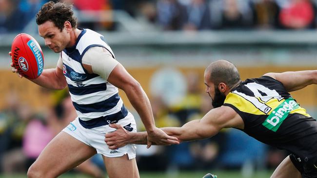 Bachar Houli of the Tigers tries to tackle Steven Motlop of the Cats.