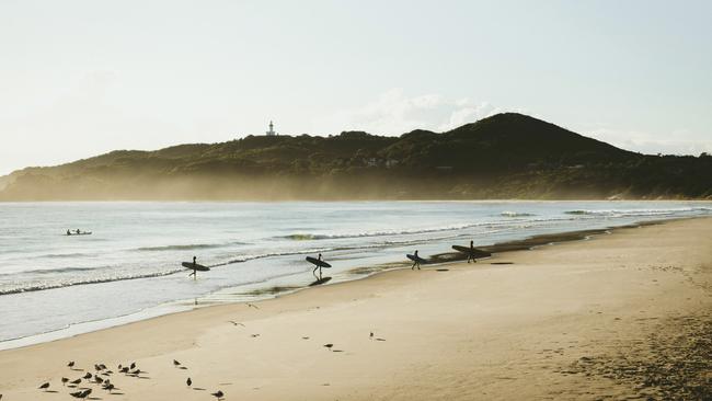 Surfers catching morning waves at Belongil Beach, Byron Bay. Picture: Destination NSW