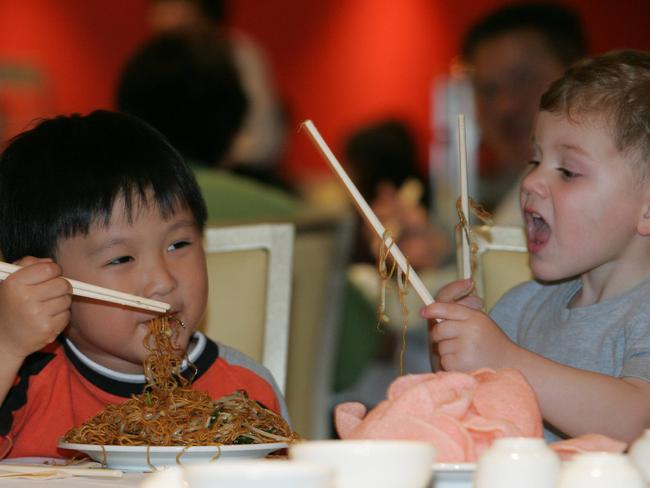 Dieu Banh, 4, and Dylan, 2, enjoying noodles in 2005. Picture: Dean Marzolla