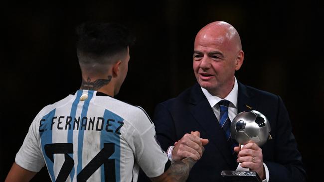 Argentina's midfielder #24 Enzo Fernandez (L) receives the FIFA Young Player award from FIFA President Gianni Infantino.