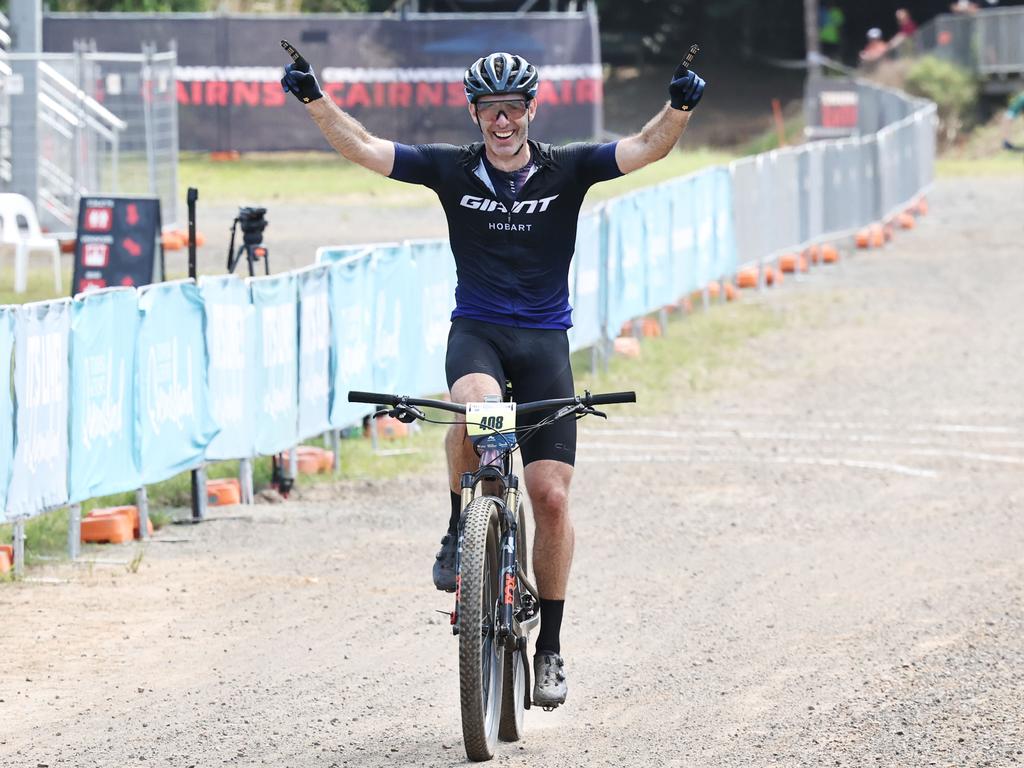 Mark Leis raises his arms in the air as he crosses the finish line to win the Male 50 to 54 years cross country class of the UCI Masters Mountain Bike World Championships, held at Smithfield Mountain Bike Park. Picture: Brendan Radke