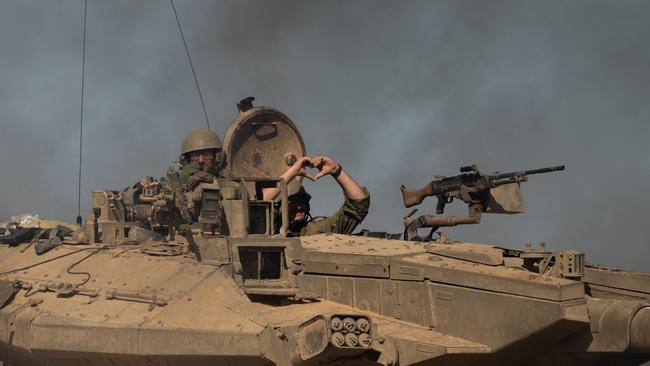 An IDF soldier makes a heart with his hands while inside a tank on November 17 in Southern Israel. Picture: Getty