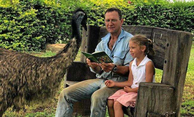 ASSISTANT TEACHER: Fred the emu joins in on reading time with dad Rob McArthur and distance education student daughter Eliza. Picture: Ainsley McArthur