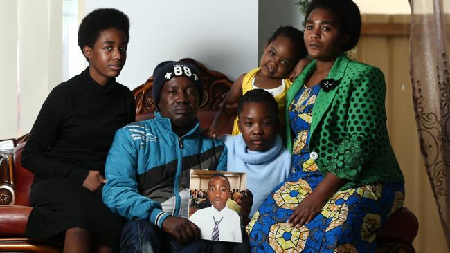 Etienne Ndikuriyo and Jacqueline Bahati hold a photo of their son Frank, as they sit with their other children Eliza, Alice and Anita. Pic: Tait Schmaal