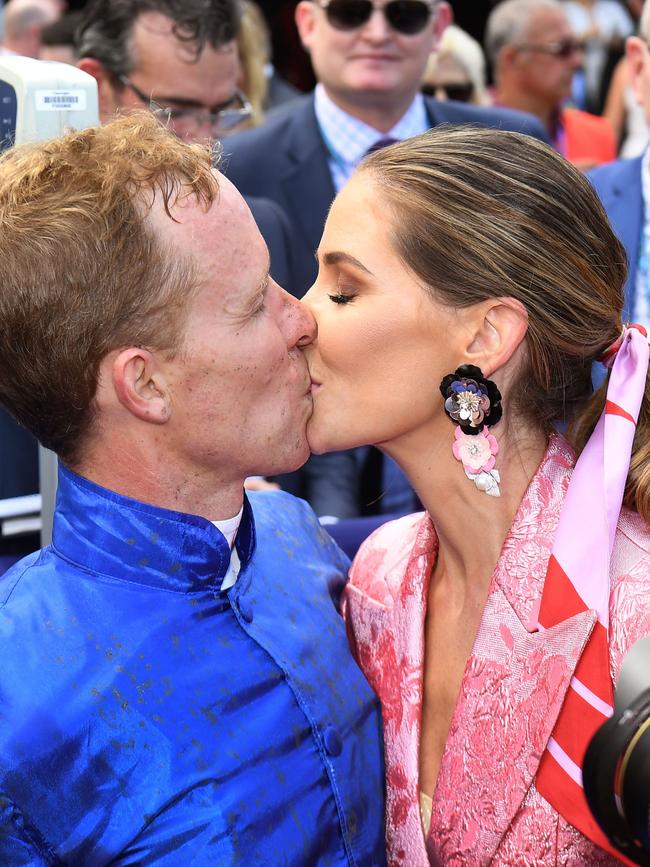 A well-deserved kiss from wife Cathy after his win. Picture: AFP