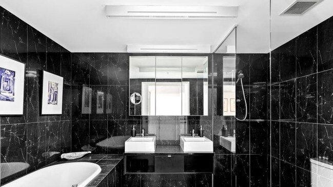 A stylish monochrome bathroom with artwork on the walls.