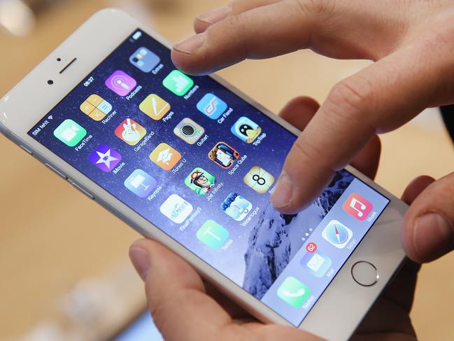 BERLIN, GERMANY - SEPTEMBER 19: A shopper ltries out the new Apple iPhone 6 at the Apple Store on the first day of sales of the new phone in Germany on September 19, 2014 in Berlin, Germany. Hundreds of people had waited in a line that went around the block through the night in order to be among the first people to buy the new smartphone, which comes in two versions: the Apple iPhone 6 and the somewhat larger Apple iPhone 6 Plus. (Photo by Sean Gallup/Getty Images)