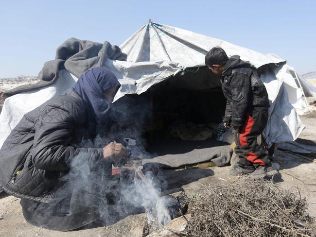 A displaced woman and child outside a tent at a makeshift camp in Bustan al-Qasr neighbourhood in the government-held northern city of Aleppo. Picture: AFP