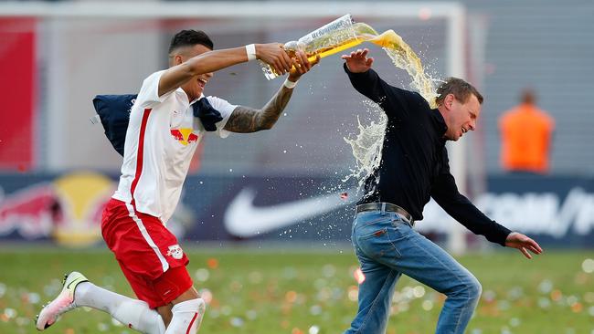 Davie Selke (L) of Leipzig showers his head coach Ralf Rangnick with beer.