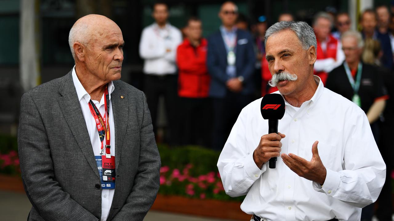 (R-L) Chase Carey talks next to Paul Little as a press conference is held outside the paddock.