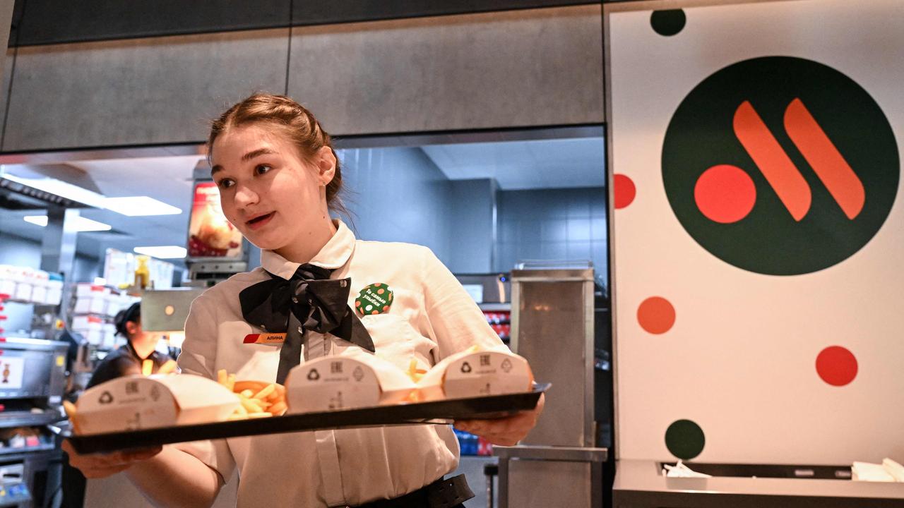 An employee holds a food order on a tray in the Russian version of a former McDonald's restaurant after the opening ceremony in Moscow on June 12. (Photo by Kirill KUDRYAVTSEV / AFP)