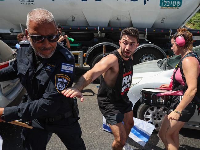 A policeman scuffles with protesters as families and supporters of Israeli hostages held by Palestinian militants in the Gaza Strip since October hold a rally calling for their release in Tel Aviv. Picture: AFP