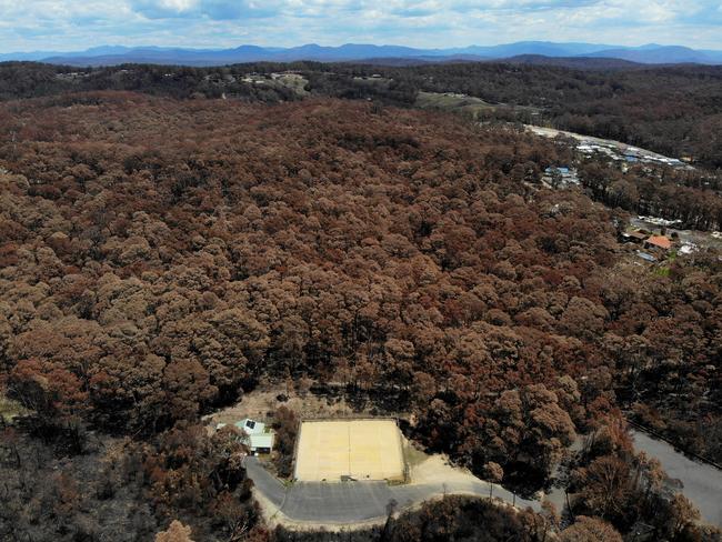 The tennis club house and courts survived while the surrounding bush was scorched. Picture: Toby Zerna