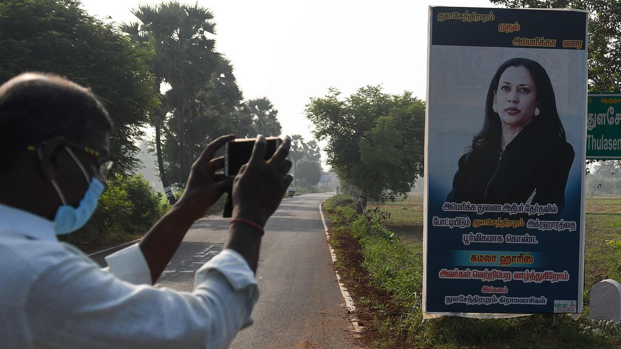 A man takes picture of a poster of Kamala Harris at her ancestral village of Thulasendrapuram in the southern Indian state of Tamil Nadu in November 2020. Picture: Arun Sankar/AFP