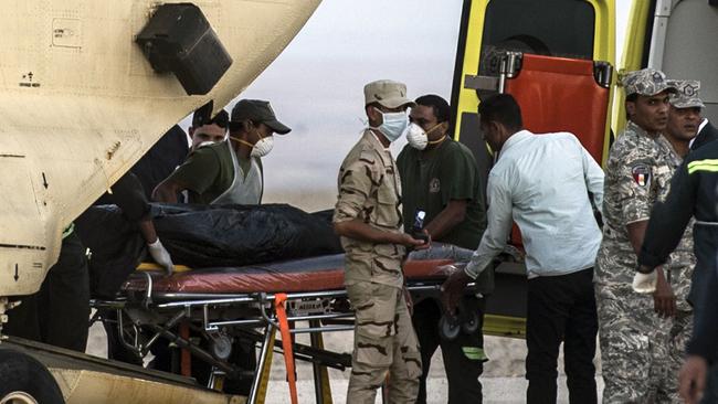 Grisly work ... Egyptian paramedics load the corpses of victims of a Russian passenger plane crash in the Sinai Peninsula, into a military plane at Kabret military air base by the Suez Canal. Picture: Khaled Desouki/AFP