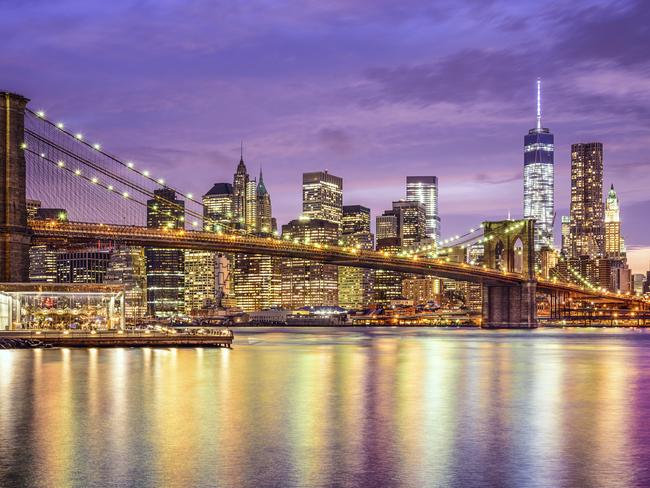 New York, New York, USA city skyline with the Brooklyn Bridge and Manhattan Financial District over the East River.