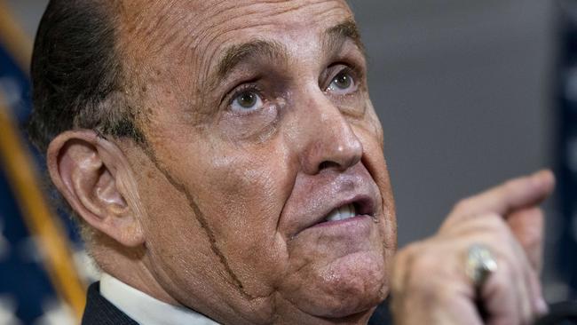 Rudy Giuliani’s hair dye runs down his face at a bizarre press conference. Picture: AFP.