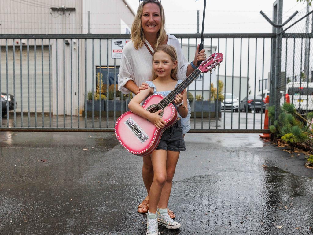 Vivenne Garrett and her mum Brooke braved the rain — complete with bedazzled guitar — hoping to see Taylor. Picture: NCA NewsWire / David Swift