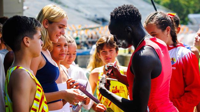 Australian sprinter Gout Gout signs autographs.