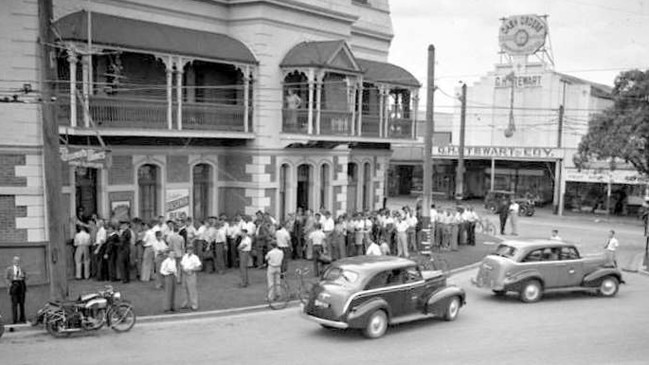 Stones Corner Hotel in 1949 with a crowd drinking on the footpath, possibly on a Saturday afternoon on their way to a rugby league match.