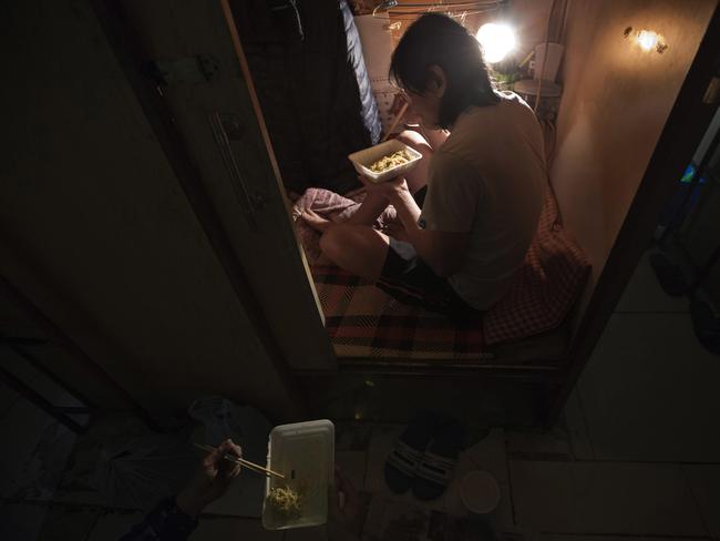 A resident who only gave his surname Lui, has dinner in his ‘coffin home’ in Hong Kong. Picture: Kin Cheung/AP