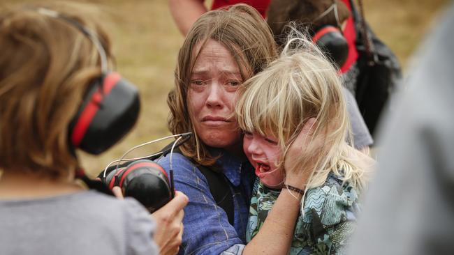 A distressed mum holds her daughter's who was refusing to wear ear protection before boarding the running Chinook helicopter leaving Malalcoota. Picture: David Caird