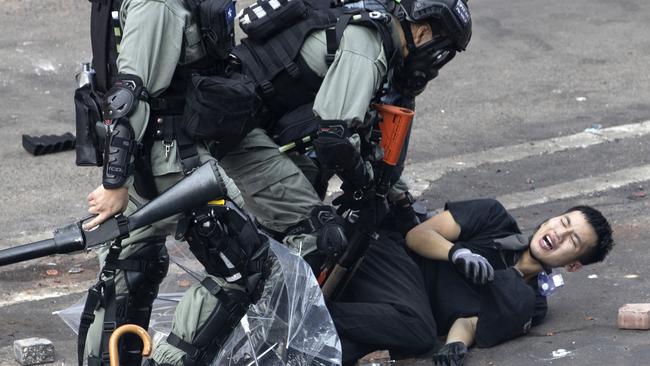 Policemen in riot gear detain a protester yesterday. Picture: AP