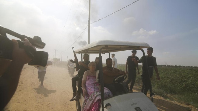 Palestinians transport a captured Israeli civilian from Kfar Azza kibbutz into the Gaza Strip on October 7. Picture: AP