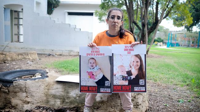 Oriya Yahbess, a cousin to the Bibas family, with photographs of her missing relatives at her home in a northern Israeli kibbutz, where the Bibas family were hoping to move. Picture: Yoni Bashan