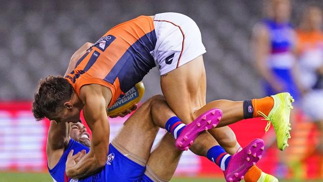 Zac Langdon of the Giants is tackled by Jason Johannisen of the Bulldogs.