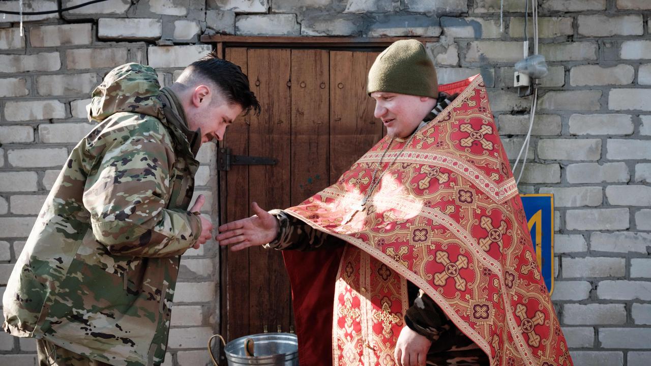 Mykola Berezyk, right, 28, Chaplain to the Ukrainian Army’s 95th Air Assault Brigade, also known as “Father Mykolaâ, conducts a prayer for Ukrainian servicemen before their departure to the frontline in the Donetsk region. Picture: AFP