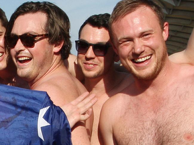 In this Sunday, Oct. 2, 2016 photo, Australian men pose for a photo in Budgy Smuggler-brand swimsuits decorated with the Malaysian flag at the conclusion of the Malaysian Formula One Grand Prix in Sepang, Malaysia. Malaysian authorities who have detained nine Australians for three nights would regard their actions in stripping down to their briefs and drinking beer from shoes as premeditated, Australia's foreign minister said Wednesday. (AP Photo)
