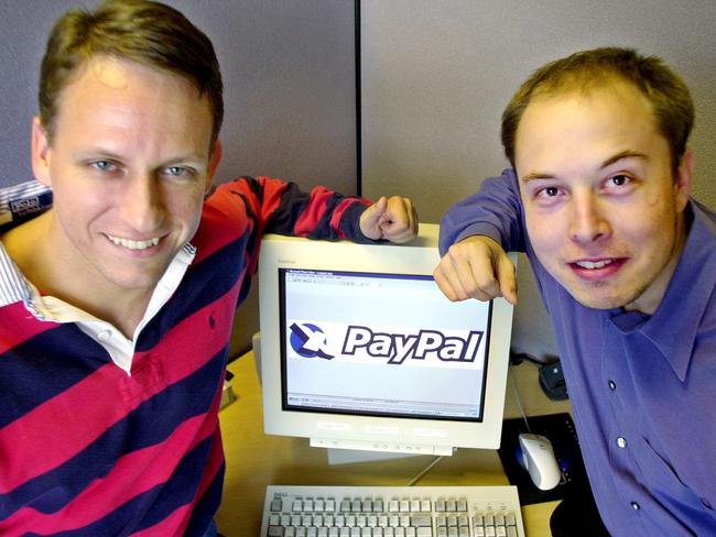 PayPal Chief Executive Officer Peter Thiel and founder Elon Musk pose with the PayPal logo at corporate headquarters in Palo Alto, California in 2000.