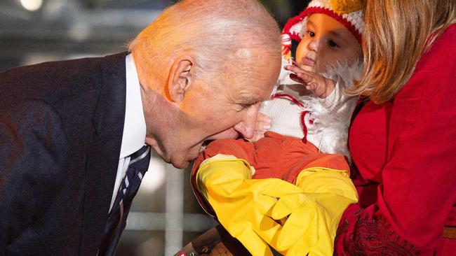 TOPSHOT - US President Joe Biden jokingly bites a baby dressed as a chicken as he hosts a Halloween trick-or-treat event at the South Portico of the White House in Washington, DC, on October 30, 2024. (Photo by Tierney CROSS / AFP)